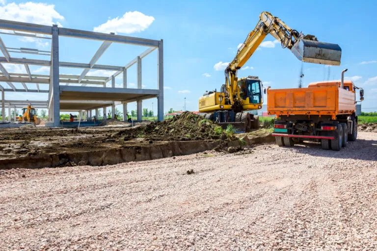 Excavator,Is,Filling,A,Dumper,Truck,With,Soil,At,Construction